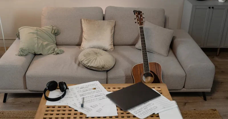 A comfortable home setting featuring a guitar on a sofa, ideal for music creation.