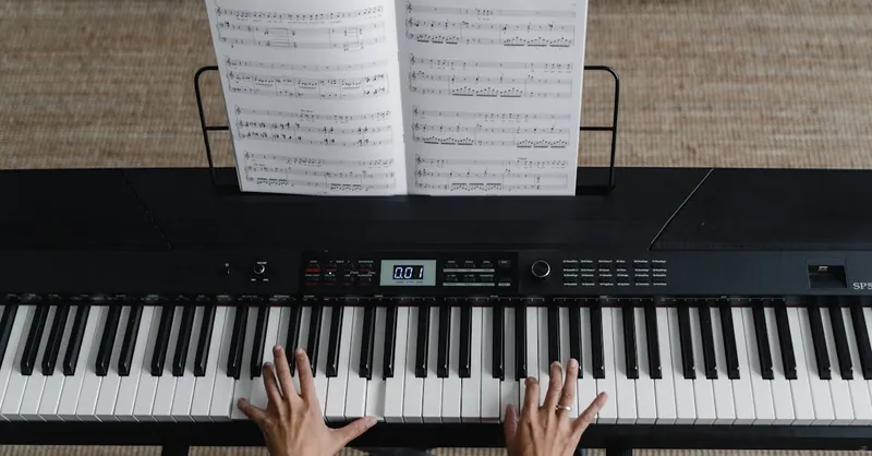 Top view of hands playing piano with sheet music on display, perfect for music learning themes.