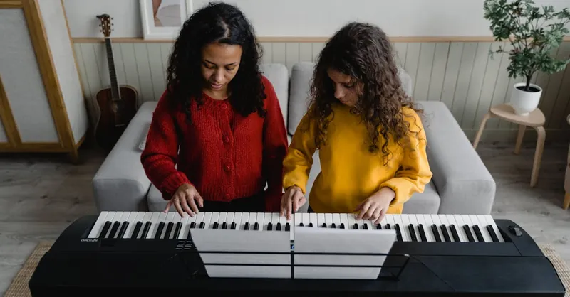 A woman and child playing piano together, enjoying a musical moment.