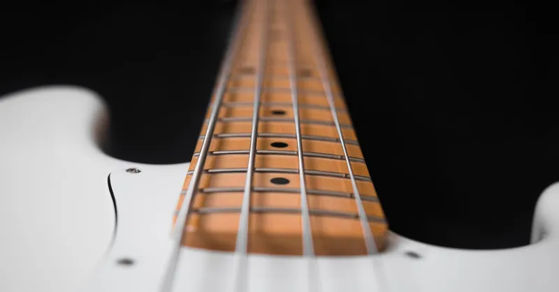 Close-up view of electric guitar strings on fretboard, sharp depth of field.