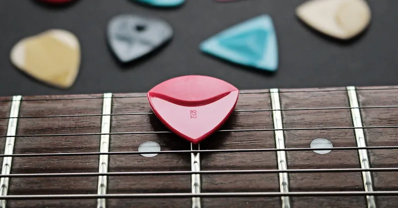 Close-up of a fretboard with colorful guitar picks showcasing musical inspiration.