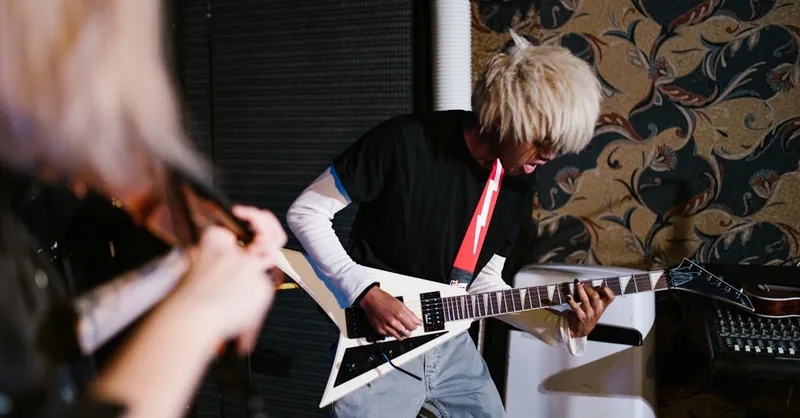 A person practicing electric guitar skillfully in an indoor music setting.