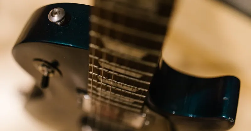 Artistic close-up of an electric guitar neck and strings, highlighting musical craftsmanship.