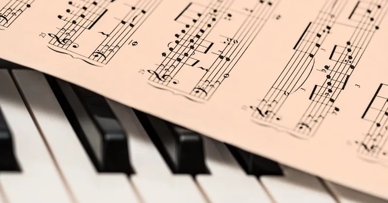 Black and white piano keys with a sheet of classical music creating a harmonious composition.