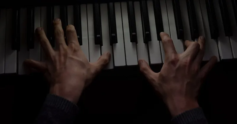 Dramatic close-up of a musician playing piano keys, capturing motion and passion.