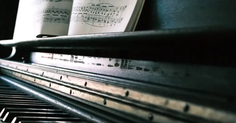 Close-up of piano keys with an open sheet music, creating a classic musical ambiance.