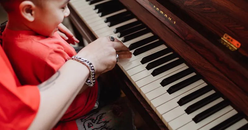 A joyful moment of a child learning piano with adult supervision, fostering musical growth.